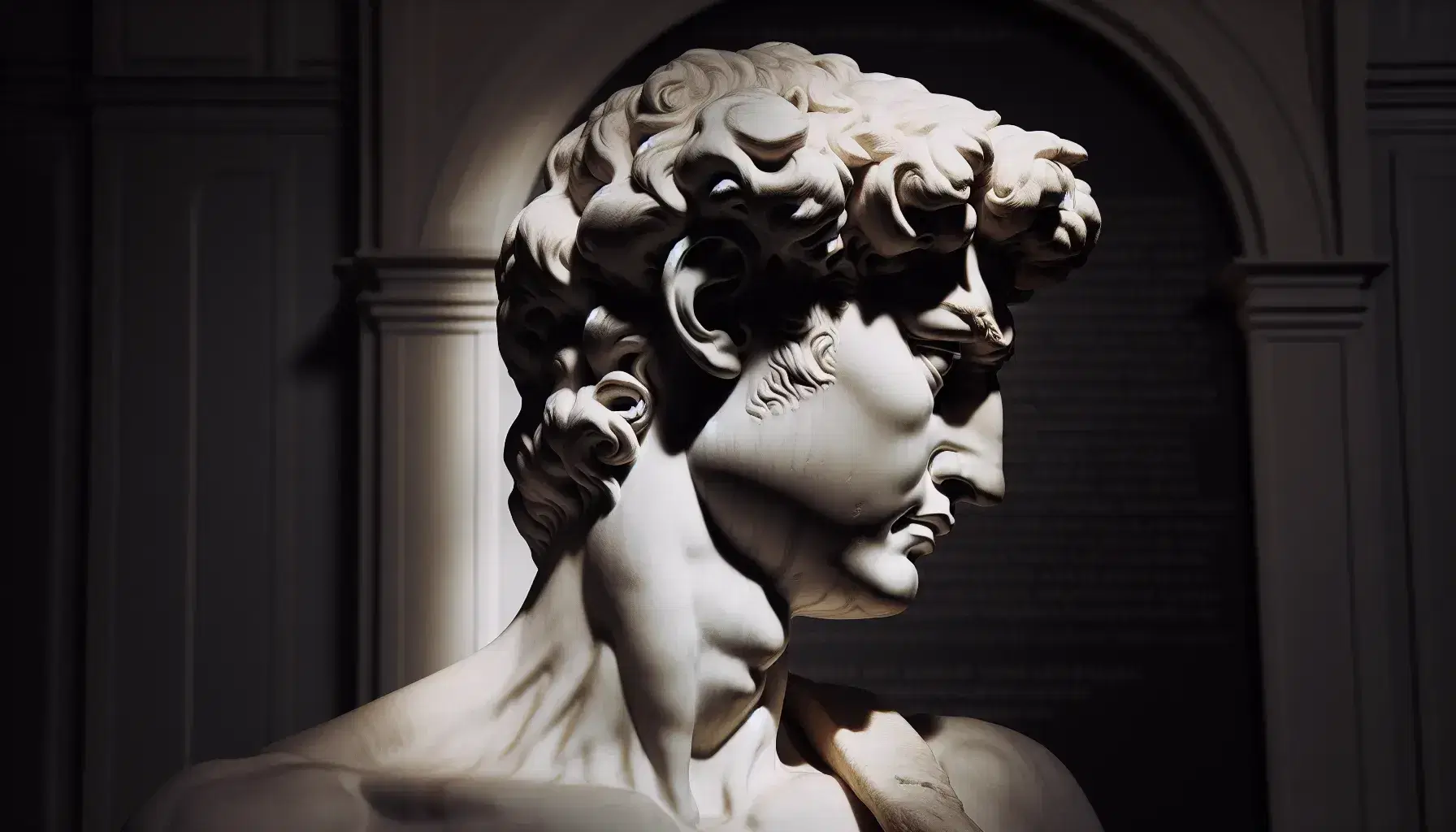 Testa e spalla destra della statua del David di Michelangelo in marmo bianco, con dettagli del viso illuminati e sfondo sfocato.