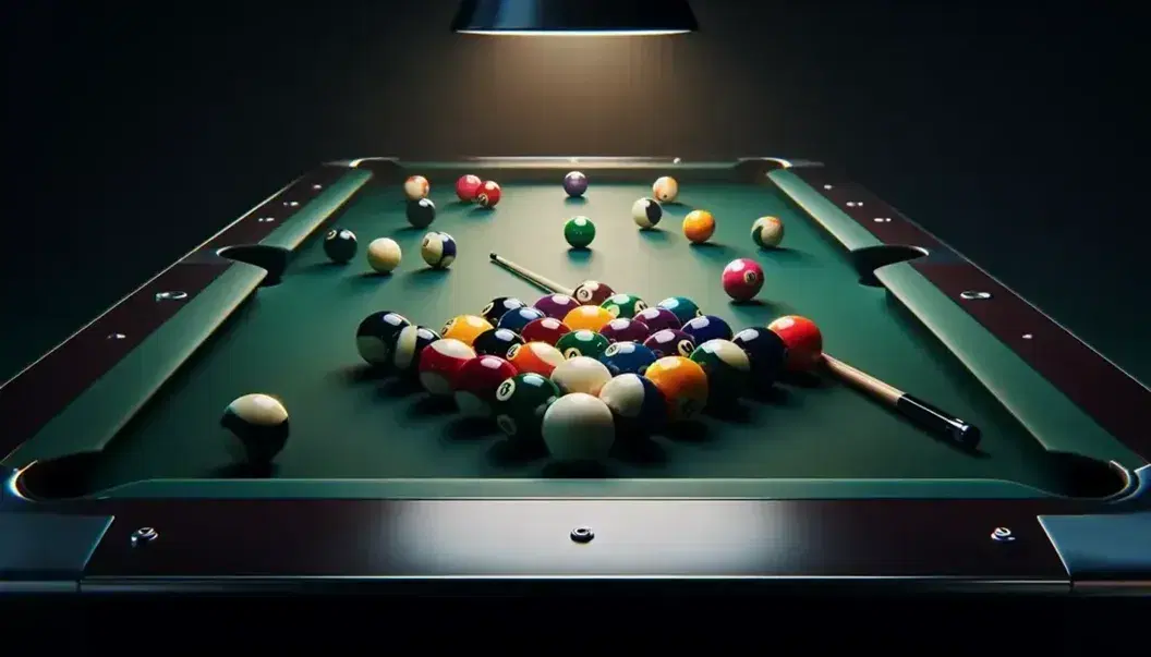 Mesa de billar verde oscuro con bolas de colores dispersas y bola blanca en el centro, iluminada por lámpara colgante, sin texto visible.