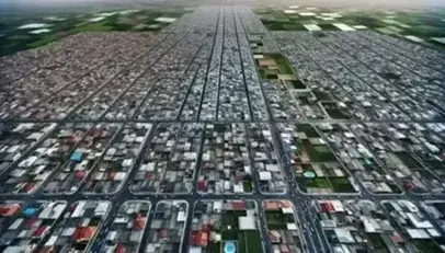 Vista aérea de la transición entre zona urbana con edificios densos y área rural con campos agrícolas, destacando espacios verdes y menor densidad de construcciones.